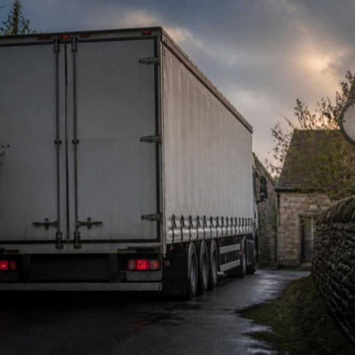 Articulated lorry wedged in a narrow stone-walled village lane after following a car sat nav